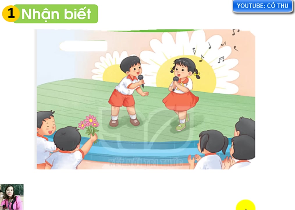 Bức tranh sinh động trong sách giáo khoa với các bạn nhỏ Nam, Hà và cả lớp đang vui vẻ ca hát.