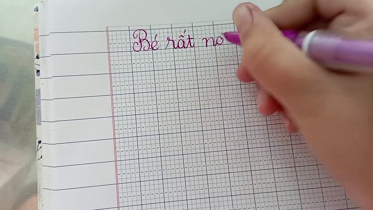 Hình ảnh minh họa bé đang chăm chú viết câu "em chăm học".